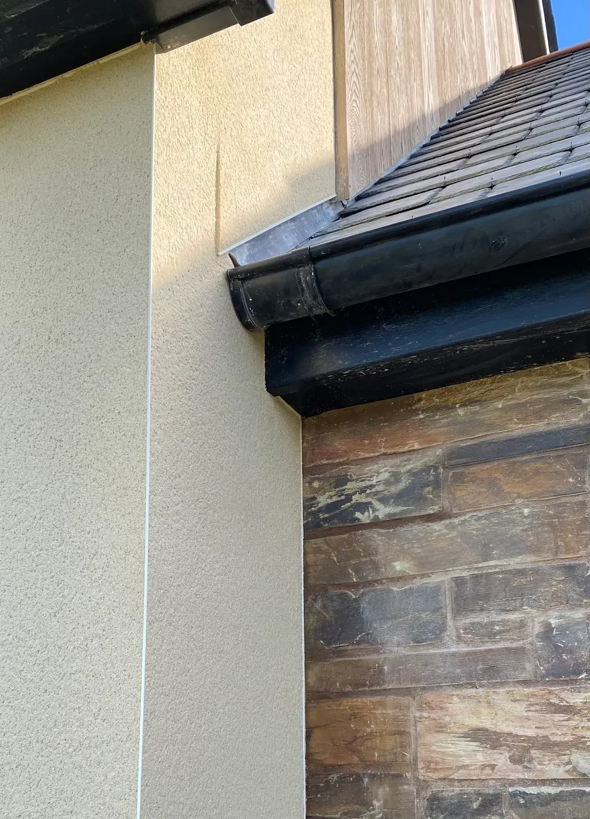 Close-up of monocouche render texture at an external corner with a slate sill