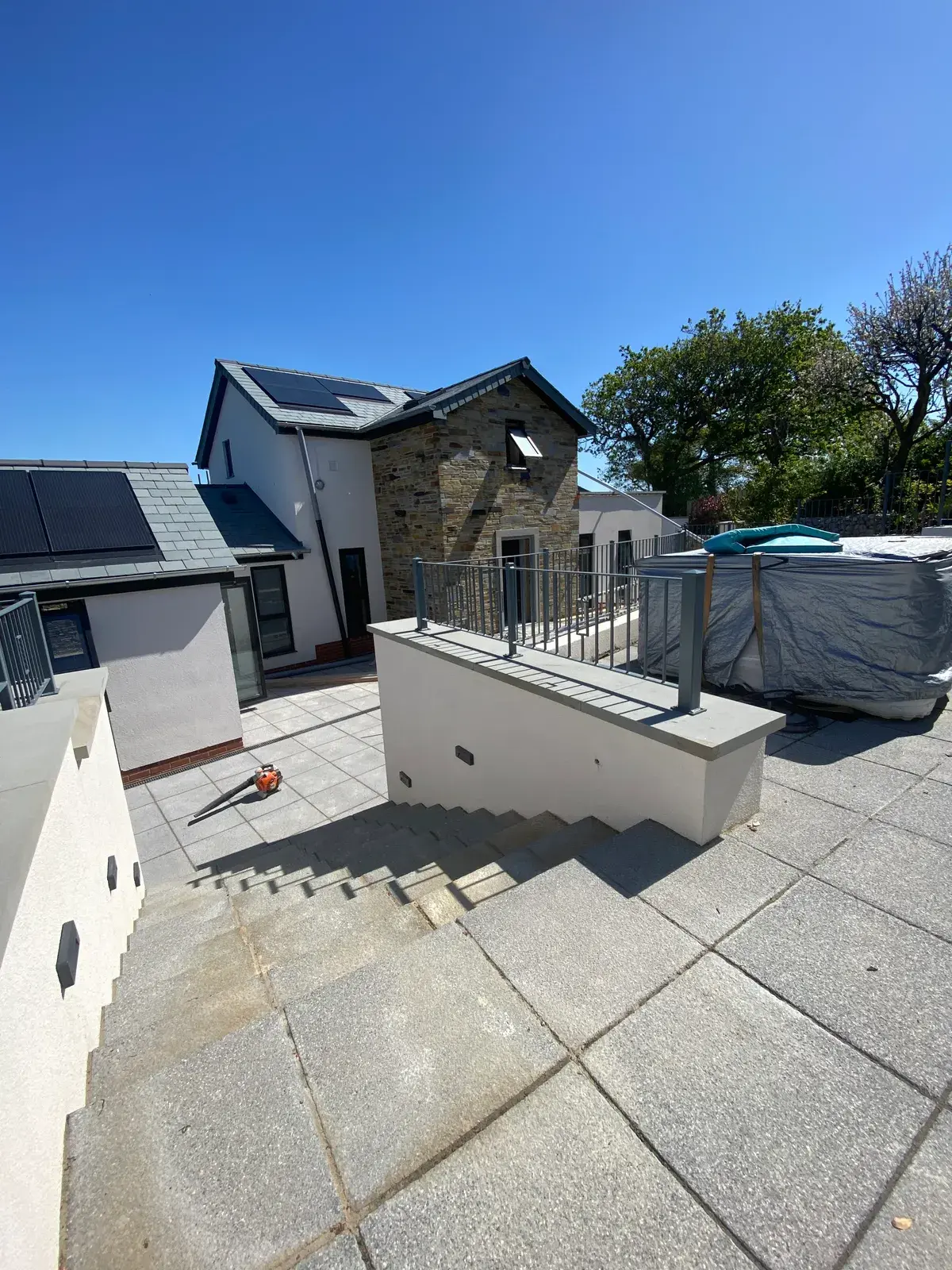 Contemporary home in silicone render with a paved patio