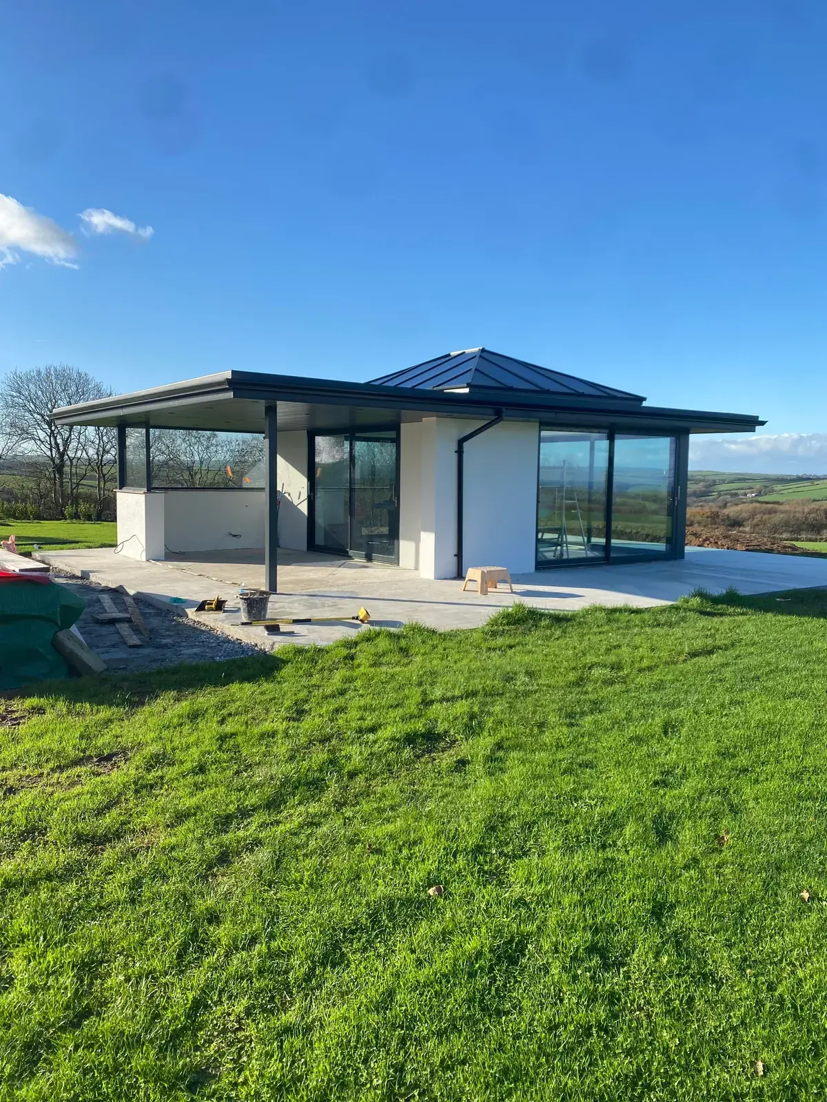 Contemporary home finished in dark silicone render with full-height glazing