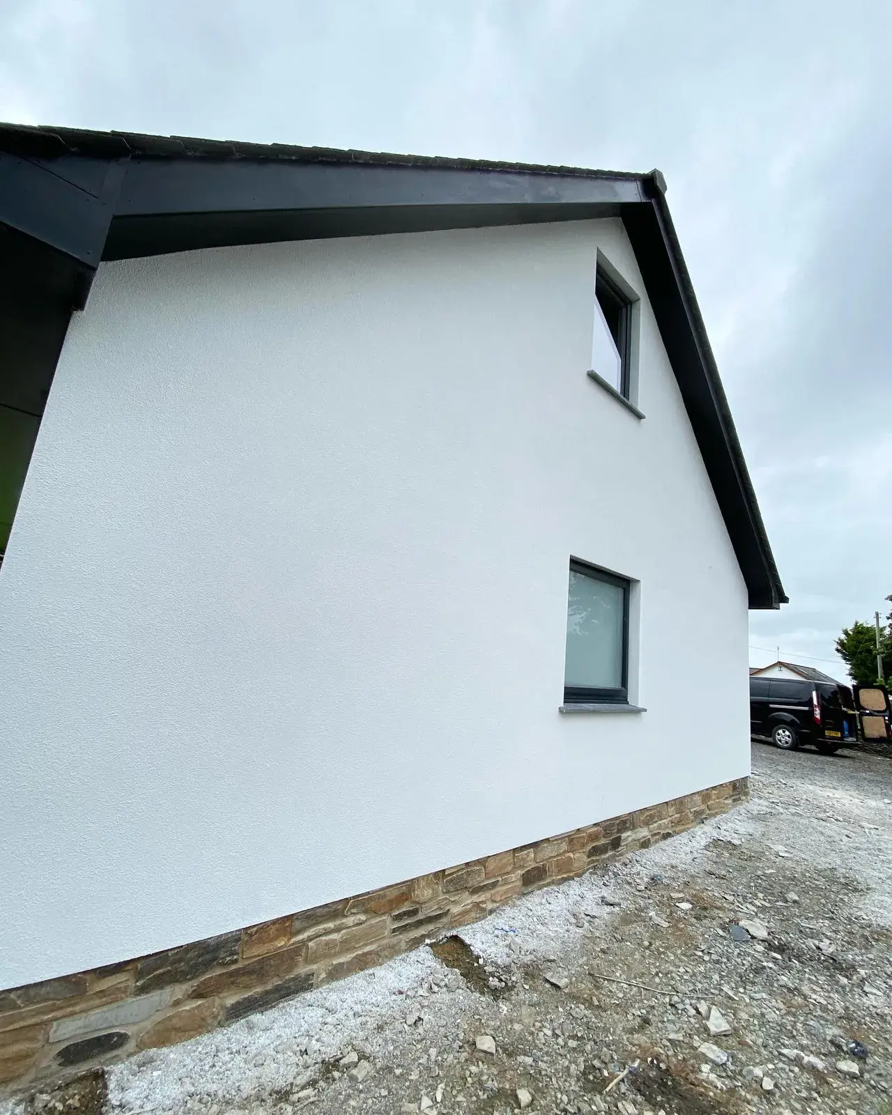 House finished in white silicone render with a crisp rendered gable