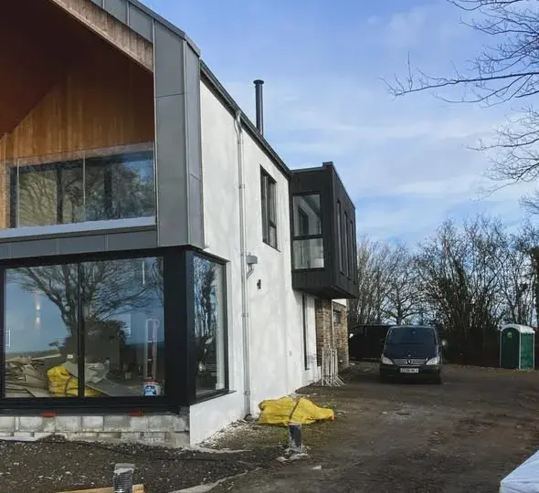 Render meeting a bay window and dark cladding